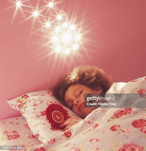 girl (6-8) asleep, bright lights above bed - covers head with pillow stock-fotos und bilder