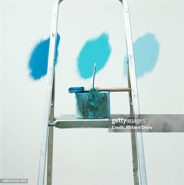 paintbrush and can on ladder in front of three shades of blue on wall - paint strip stock pictures, royalty-free photos & images