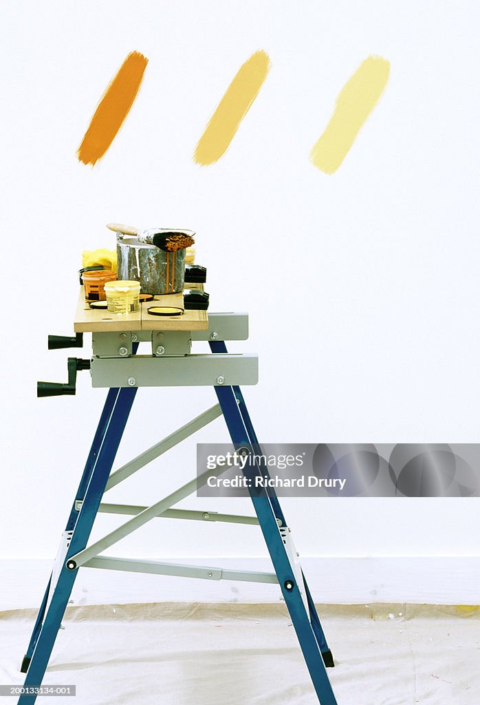 Paintbrush and pots on workbench, three shades of brown on wall