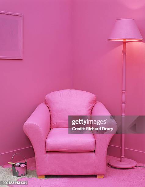 paintbrush and can on floor in room with furniture painted pink - pink color stockfoto's en -beelden