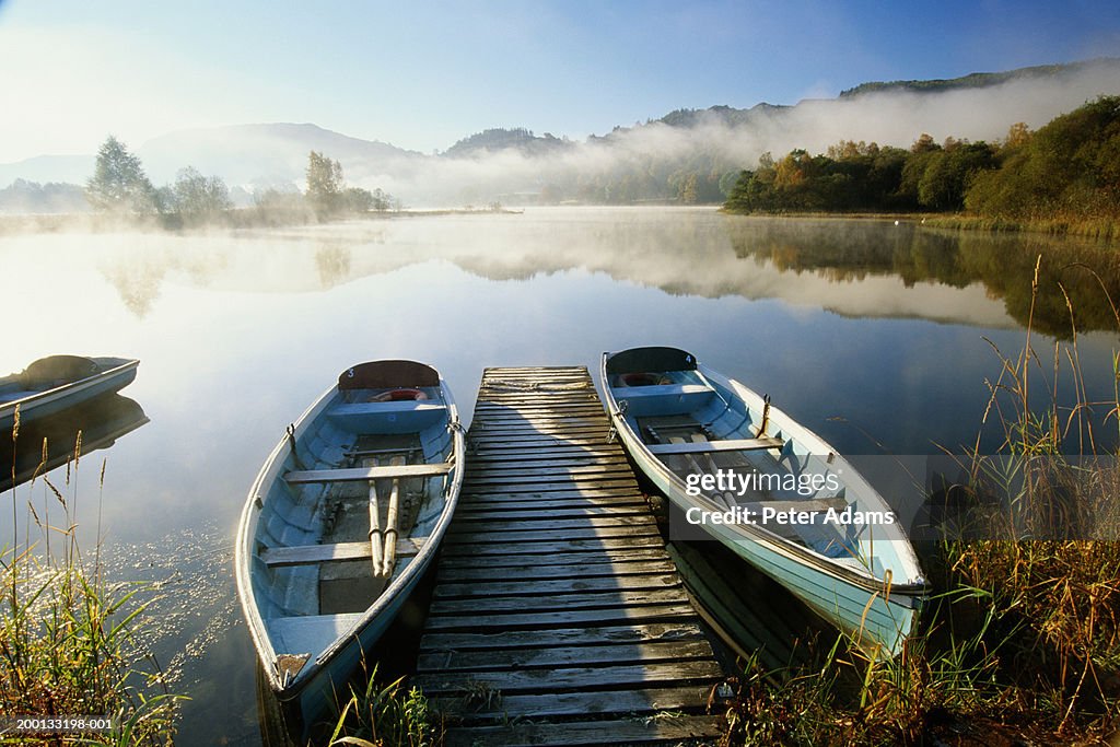 England, Cumbria, two boats either side of boardwalk on Lake Grasmere