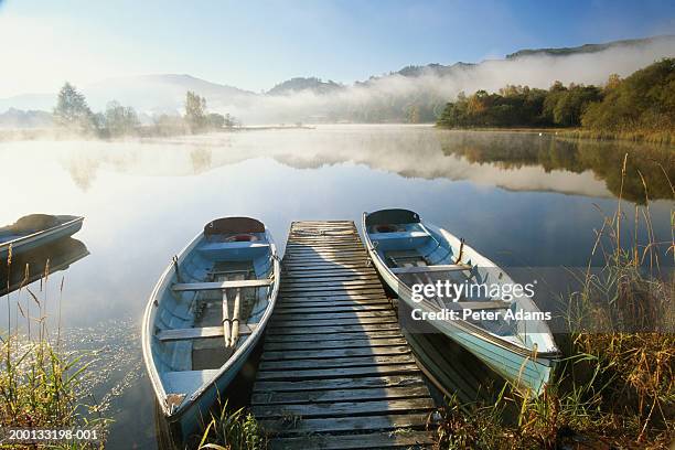 england, cumbria, two boats either side of boardwalk on lake grasmere - boats moored stock pictures, royalty-free photos & images