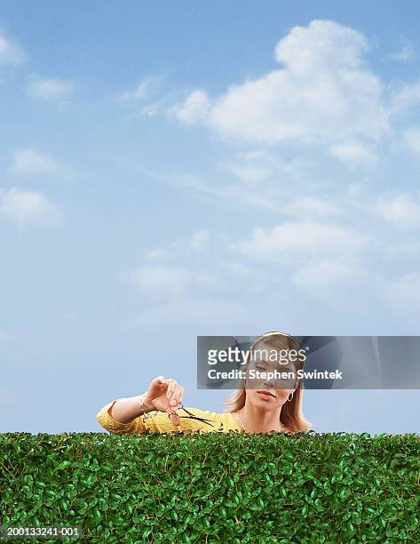 woman cutting hedge with scissors - raise the bar concept stock pictures, royalty-free photos & images