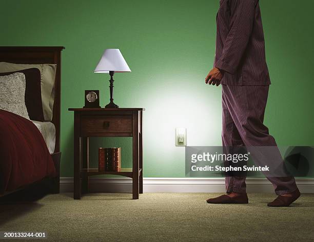 man wearing pajamas, walking towards bed, low section - luchtverfrisser stockfoto's en -beelden