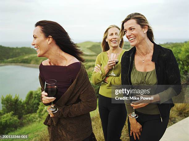 three women holding glasses of wine, outdoors - waiheke island stock pictures, royalty-free photos & images