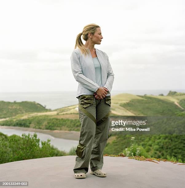 woman standing outdoors - blond undone stock-fotos und bilder