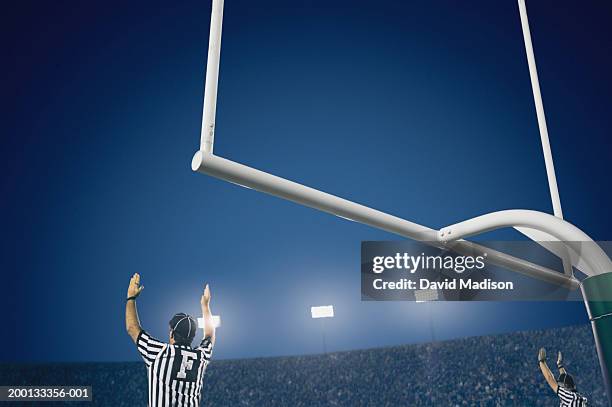 two american football referees giving touchdown signal, rear view - goalpost stock-fotos und bilder