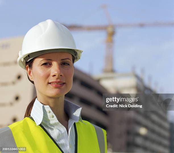 woman wearing safety vest and hard hat, portrait, close-up - green blouse stock pictures, royalty-free photos & images