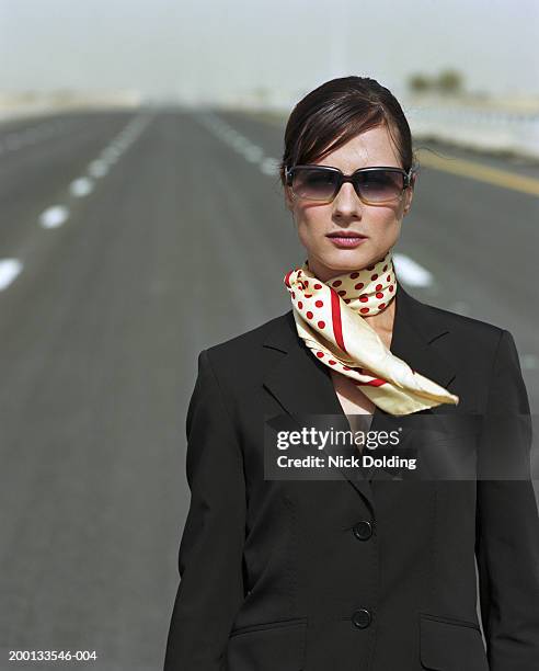 young woman standing in midddle of road, portrait - großes halstuch stock-fotos und bilder