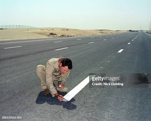 man painting white line on road with small brush - perfezione foto e immagini stock