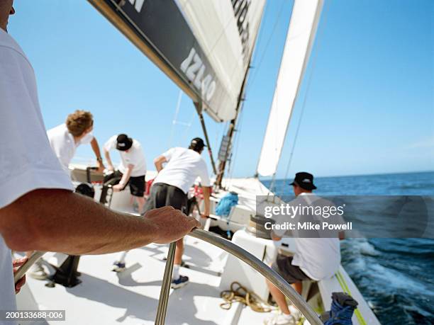 man standing at helm, sailing ocean going racing yacht - sportteam stockfoto's en -beelden