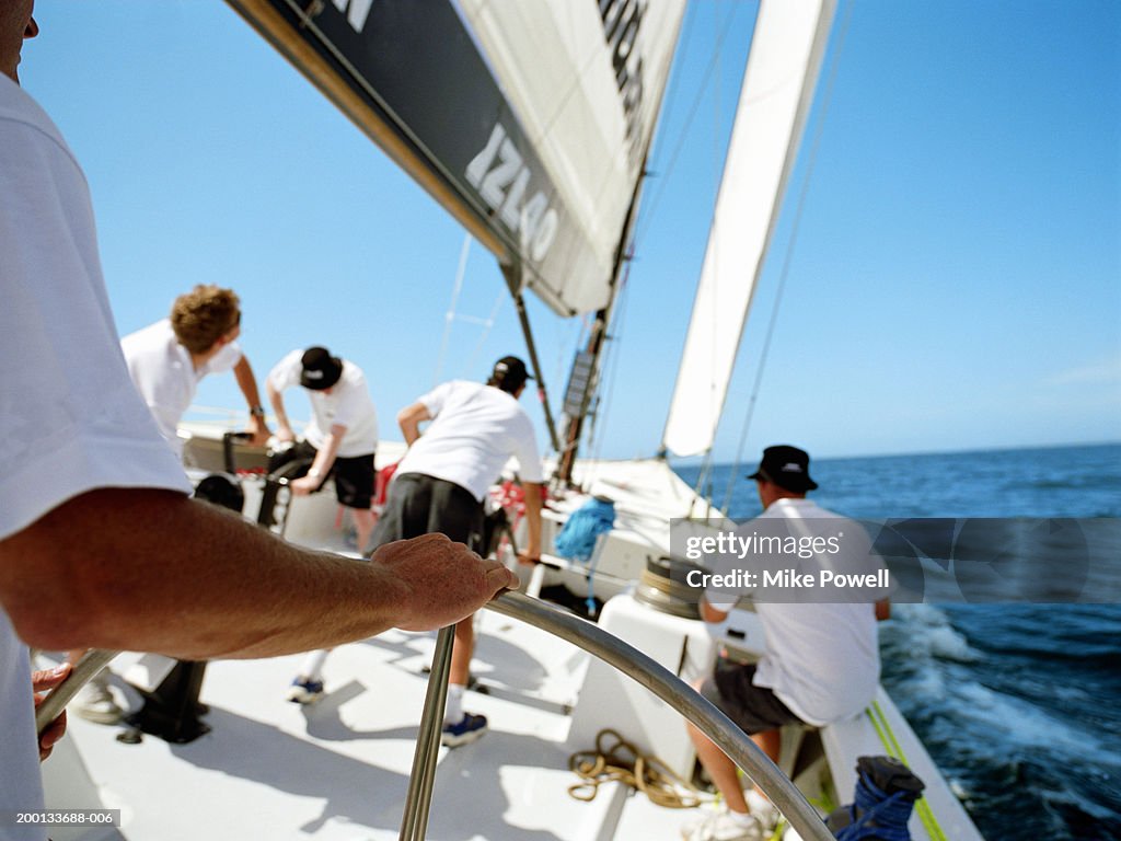 Man standing at helm, sailing ocean going racing yacht