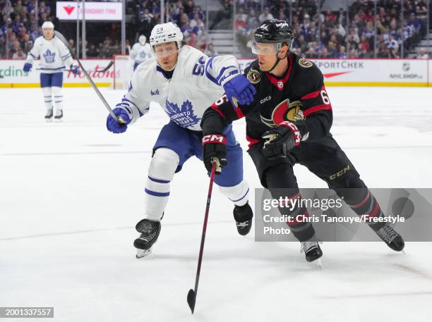 Tyler Bertuzzi of the Toronto Maple Leafs battles with Jakob Chychrun of the Ottawa Senators during the first period at Canadian Tire Centre on...