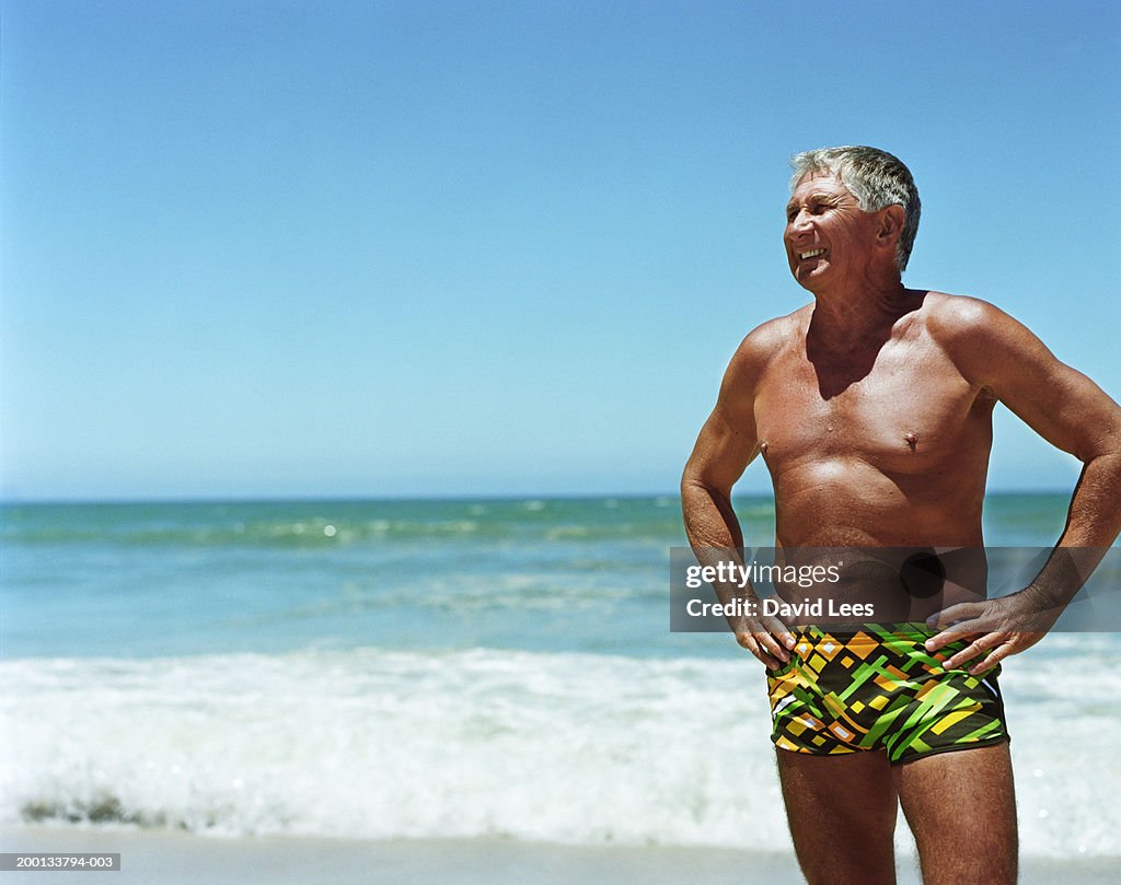 Mature man on beach, hands on hips