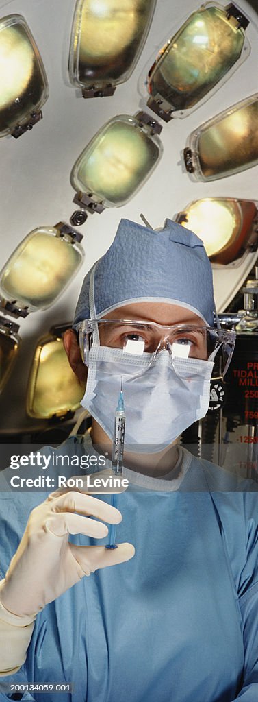 Female doctor holding syringe in operating room