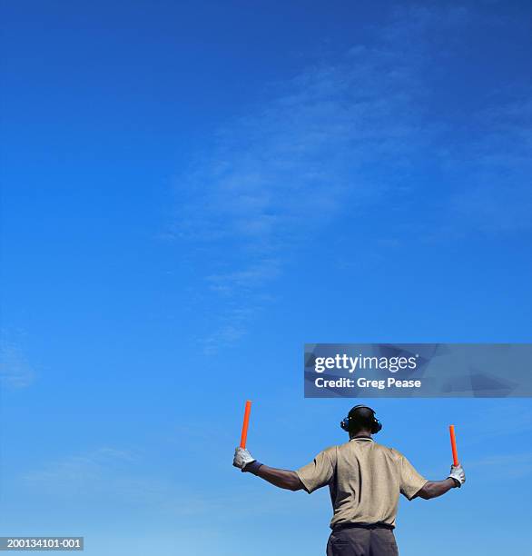 ground crew member directing aircraft, rear view (digital enhancement) - air traffic control stock-fotos und bilder