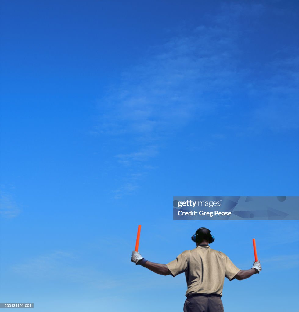 Ground crew member directing aircraft, rear view (Digital Enhancement)