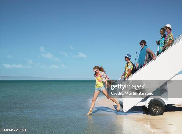 five people descending aeroplane stairs into sea, side view - shallow stock pictures, royalty-free photos & images