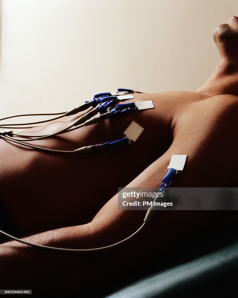 Male patient undergoing electrocardiogram, mid section, side view
