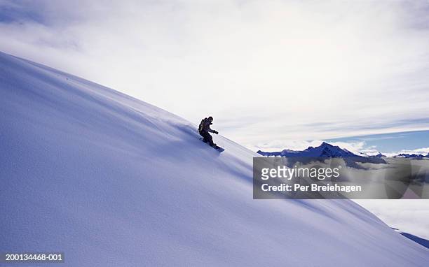 man snowboarding on mountain, sideview - one per stock pictures, royalty-free photos & images
