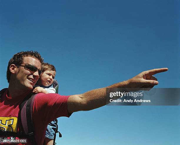 man with baby (12-15 months) on back, pointing, close-up - baby hands pointing stock pictures, royalty-free photos & images