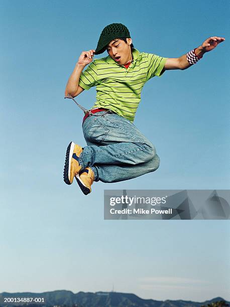 young man jumping in air, portrait, low angle - running shoes sky stock-fotos und bilder