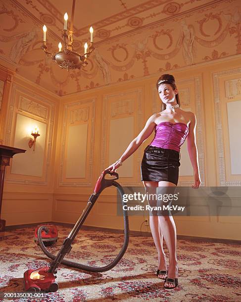 fashionably dressed woman vacuuming - beehive hair stock-fotos und bilder