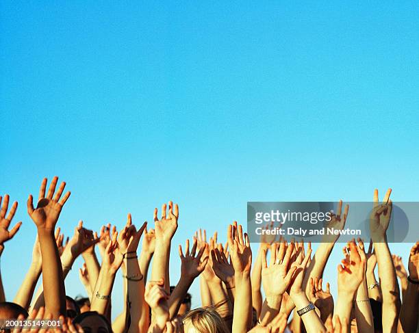 group of young people's hands raised, outdoors - braccia alzate foto e immagini stock