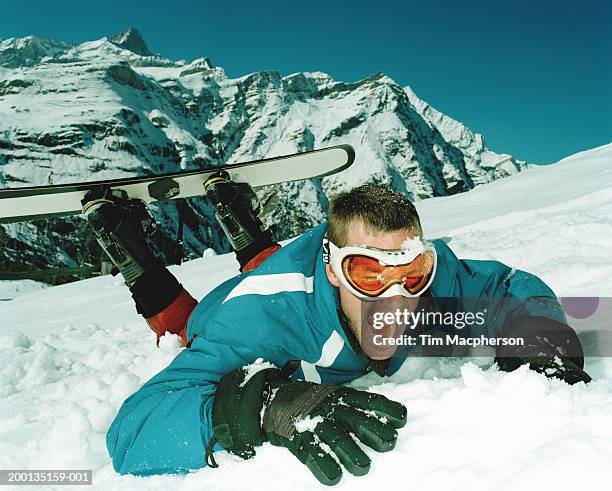 male snowboarder lying on snow laughing - snow board stock pictures, royalty-free photos & images