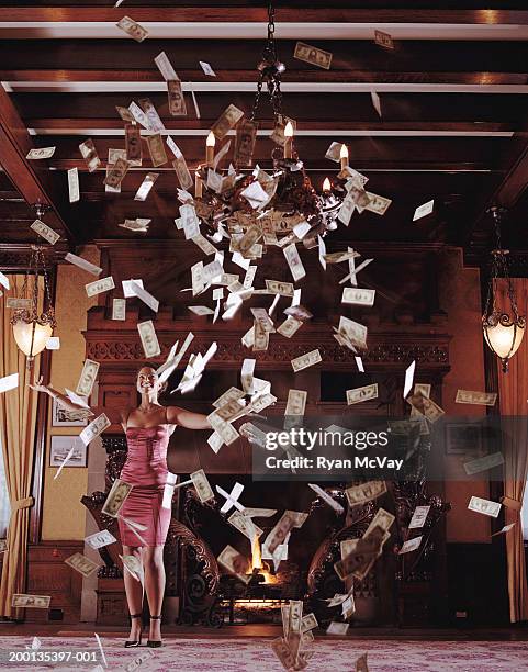 young woman with arms outstretched, surrounded by falling banknotes - african american woman with money stock-fotos und bilder