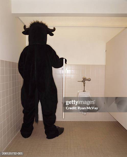 person in bull costume using urinal, rear view - urinal stock pictures, royalty-free photos & images