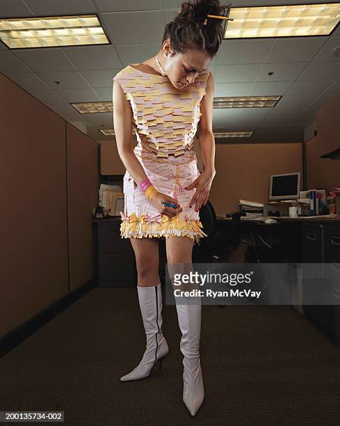 woman in dress made of office supplies, making a note on her skirt - asian ceiling stock-fotos und bilder