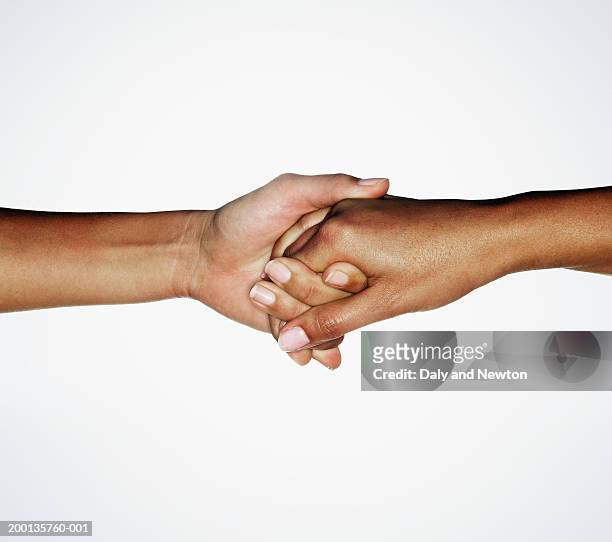 two young women linking hands, close up - darsi la mano foto e immagini stock