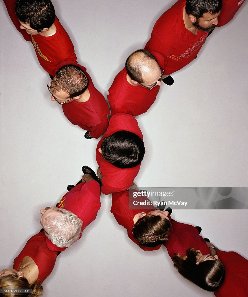 Group of adults standing in 'X' formation, overhead view