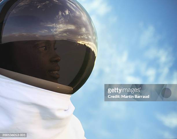 female astronaut outdoors, close up, side view - astronaut helmet stock-fotos und bilder