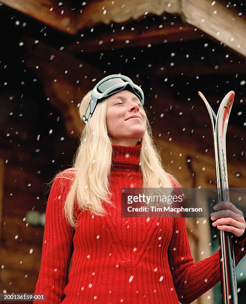 young woman in snow holding skis, eyes closed - ski wear stock pictures, royalty-free photos & images
