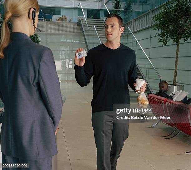 man showing id card to security woman - security badge stock pictures, royalty-free photos & images