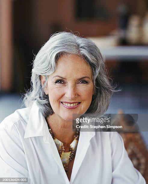 mature woman wearing white shirt and necklace,  portrait - bruine ogen stockfoto's en -beelden