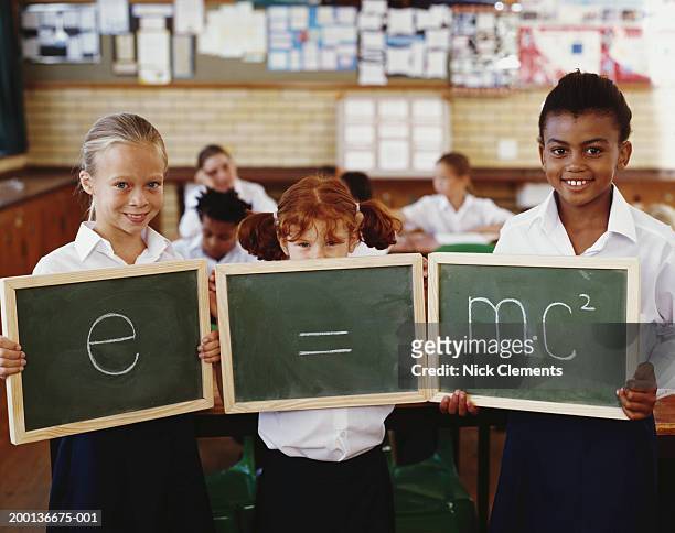 children (8-10) holding blackboards displaying equation, portrait - einstein stock pictures, royalty-free photos & images