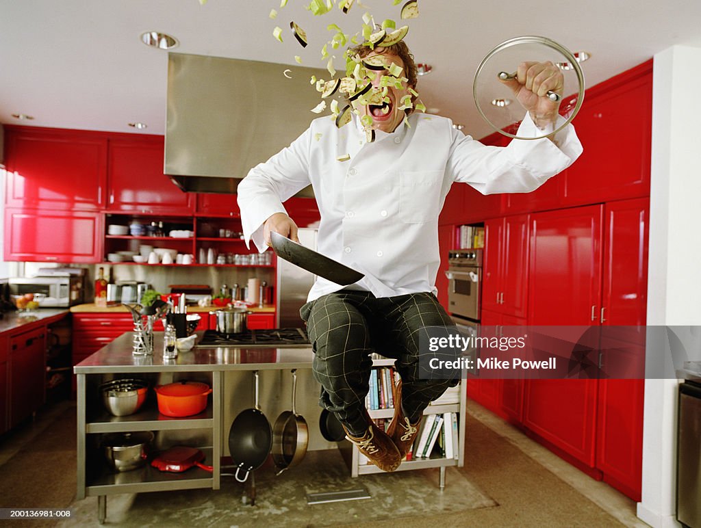 Chef jumping in air, contents of pan flying out