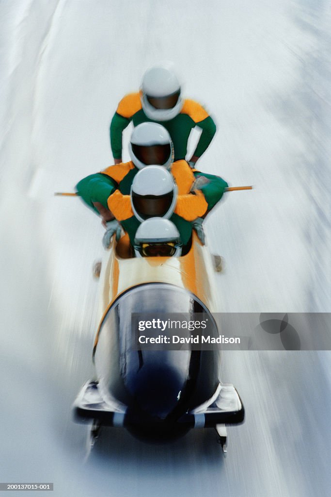 Four man bobsled team mounting their sled (blurred motion)