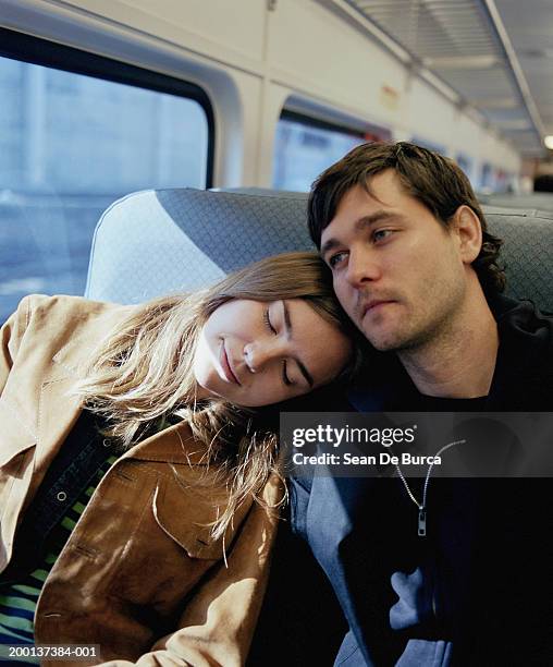 couple on train, woman resting head on man's shoulder - boyfriend foto e immagini stock