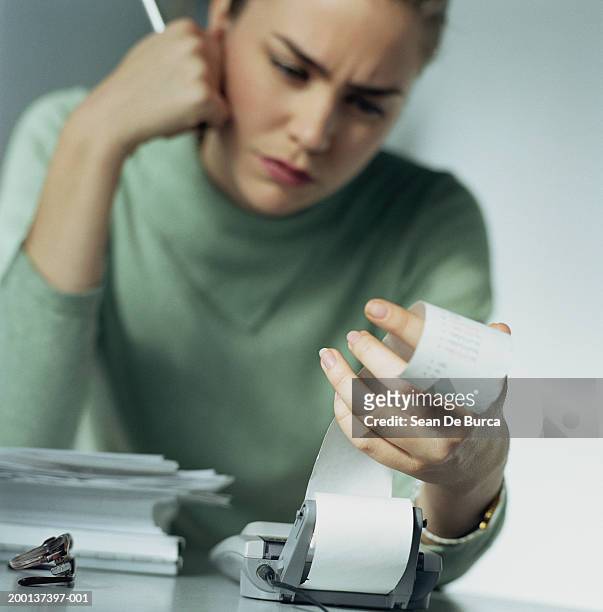 woman looking at calculator tape in office (focus on hand) - adding machine tape stock pictures, royalty-free photos & images