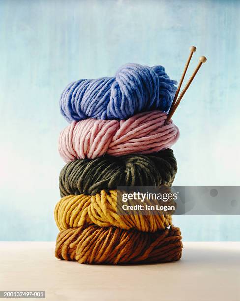 stack of colorful yarns with knitting needles - wollig stockfoto's en -beelden