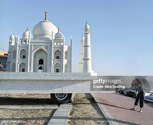 woman taking photo of taj mahal model on back of truck - emirati lady from back stock-fotos und bilder