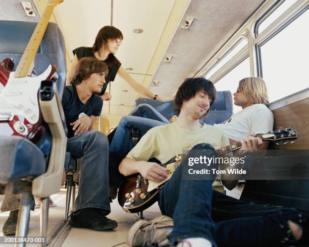 four young people on bus, man playing guitar - tourist bus stock pictures, royalty-free photos & images