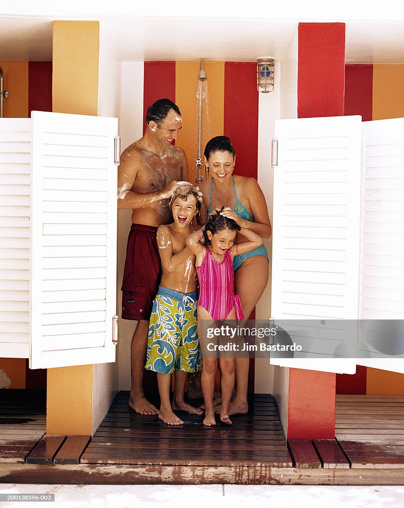 Parents and children (5-9) showering at beach