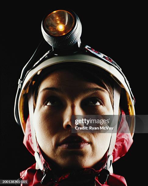 young woman wearing sports helmet and headlamp, looking up - hoofdlamp stockfoto's en -beelden