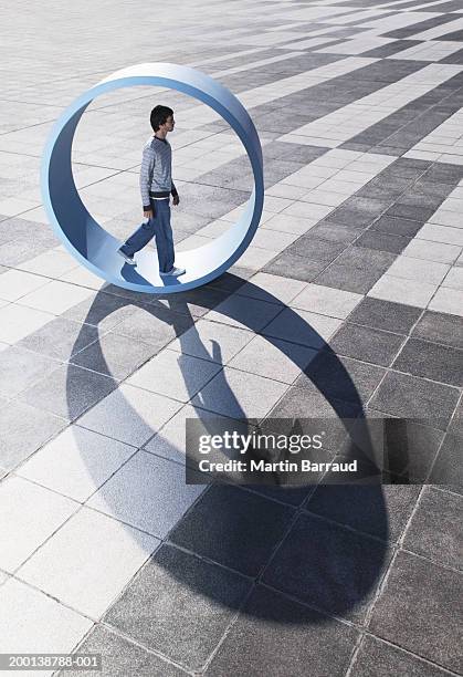 man walking in large wheel outdoors - hopelessness stock pictures, royalty-free photos & images