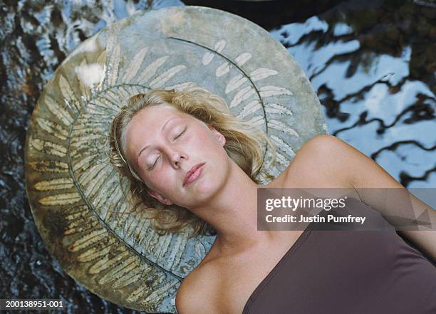 young woman lying across stepping stones, eyes closed, close-up - stepping stone top view stock pictures, royalty-free photos & images